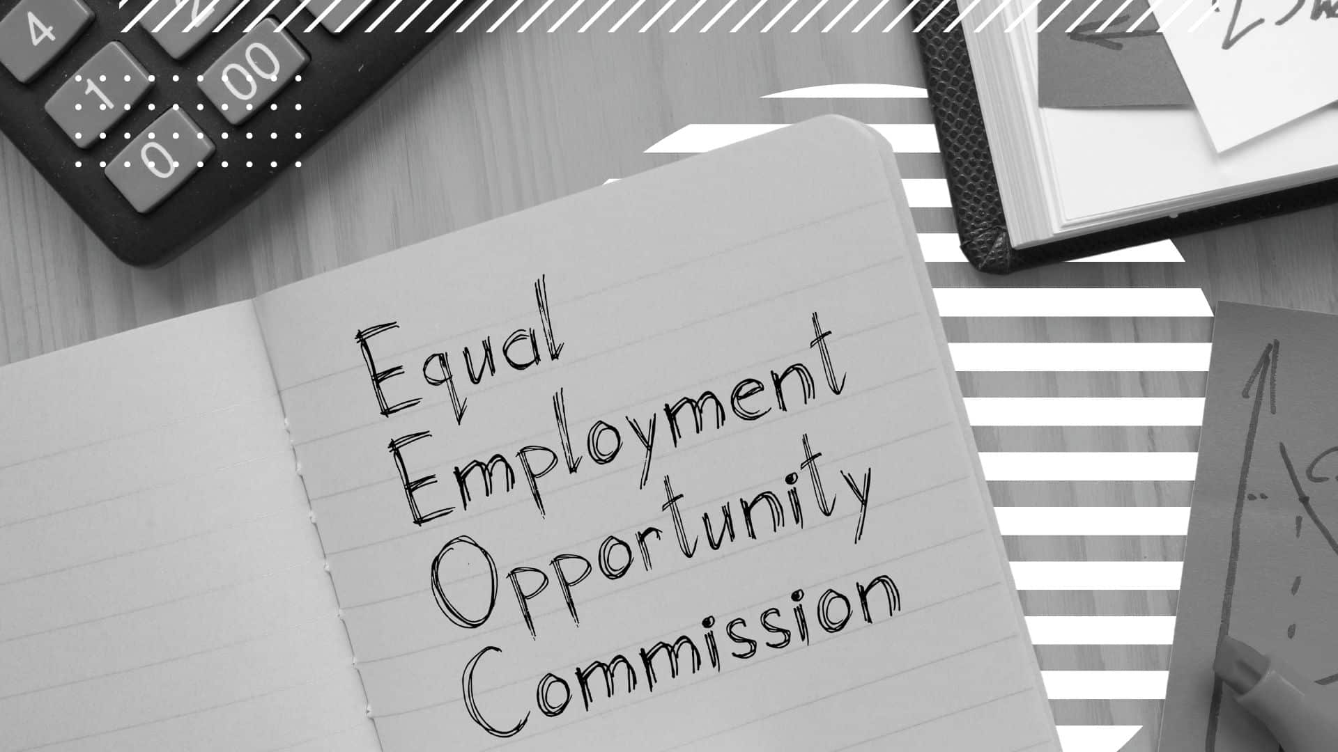 a notebook sits on a desk with "Equal Employment Opportunity Commission" written on the paper" - beside it is a calculator and a book, both just outside of the frame