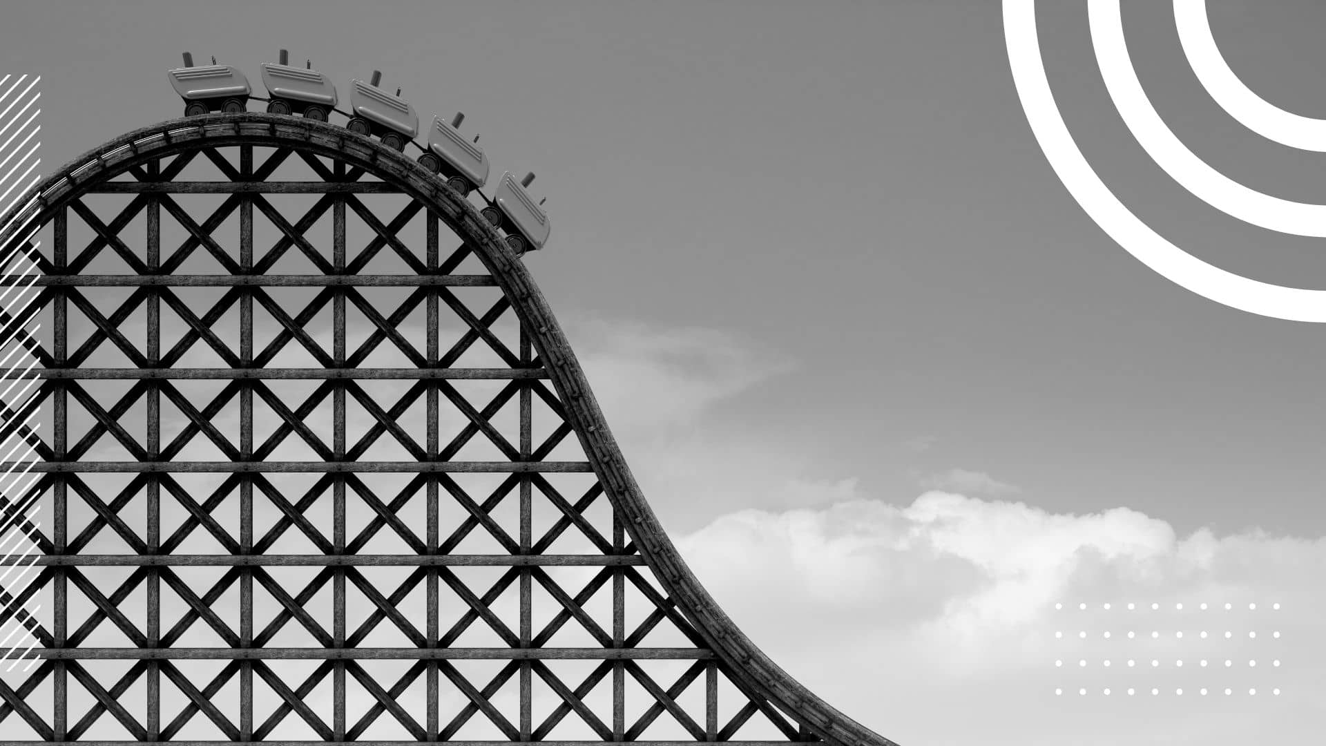 black and white photo of a roller coaster, the cars are just about to head down the slope