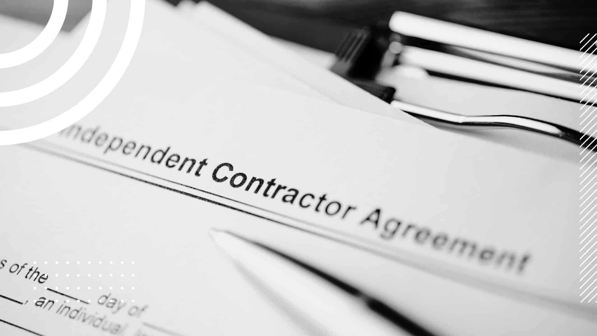 close up of an Independent Contractor Agreement page on a clipboard with a pen resting on it