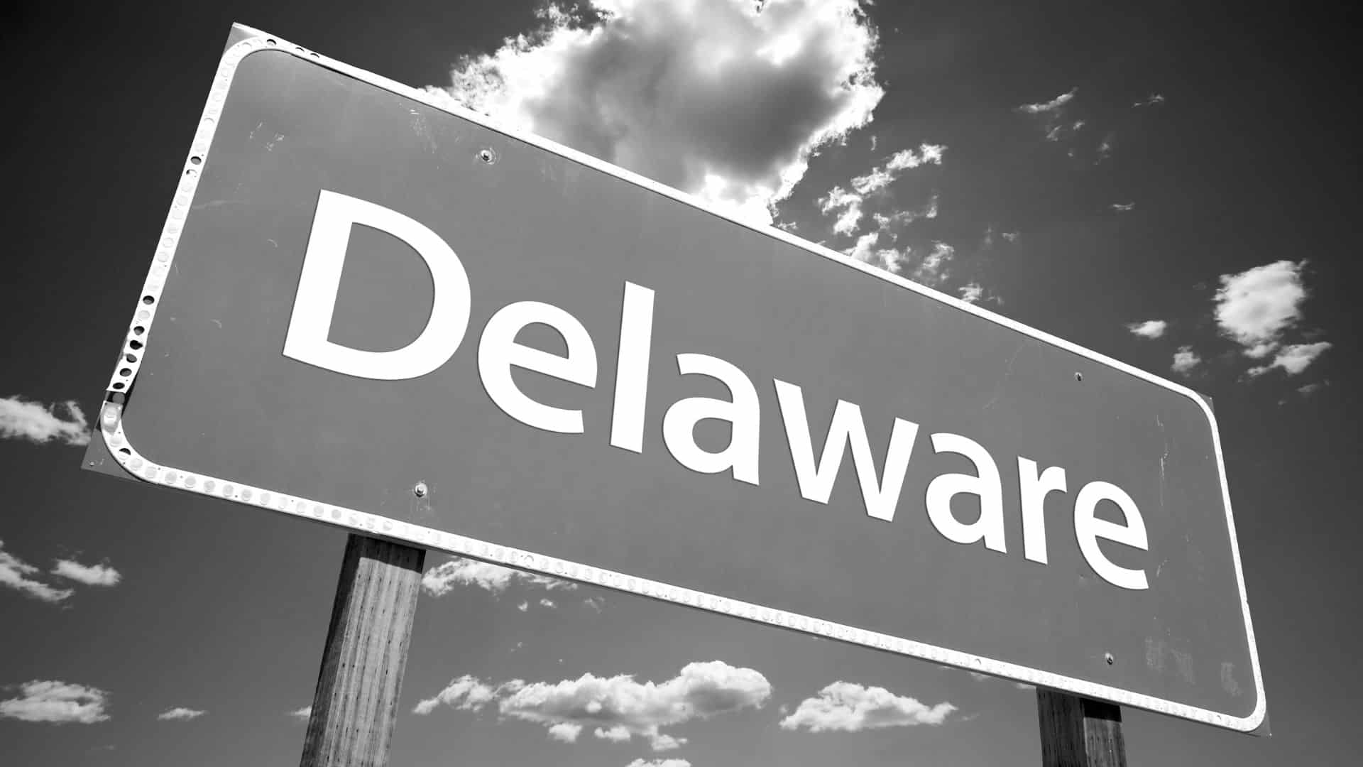 large sign for Delaware against a cloudy sky