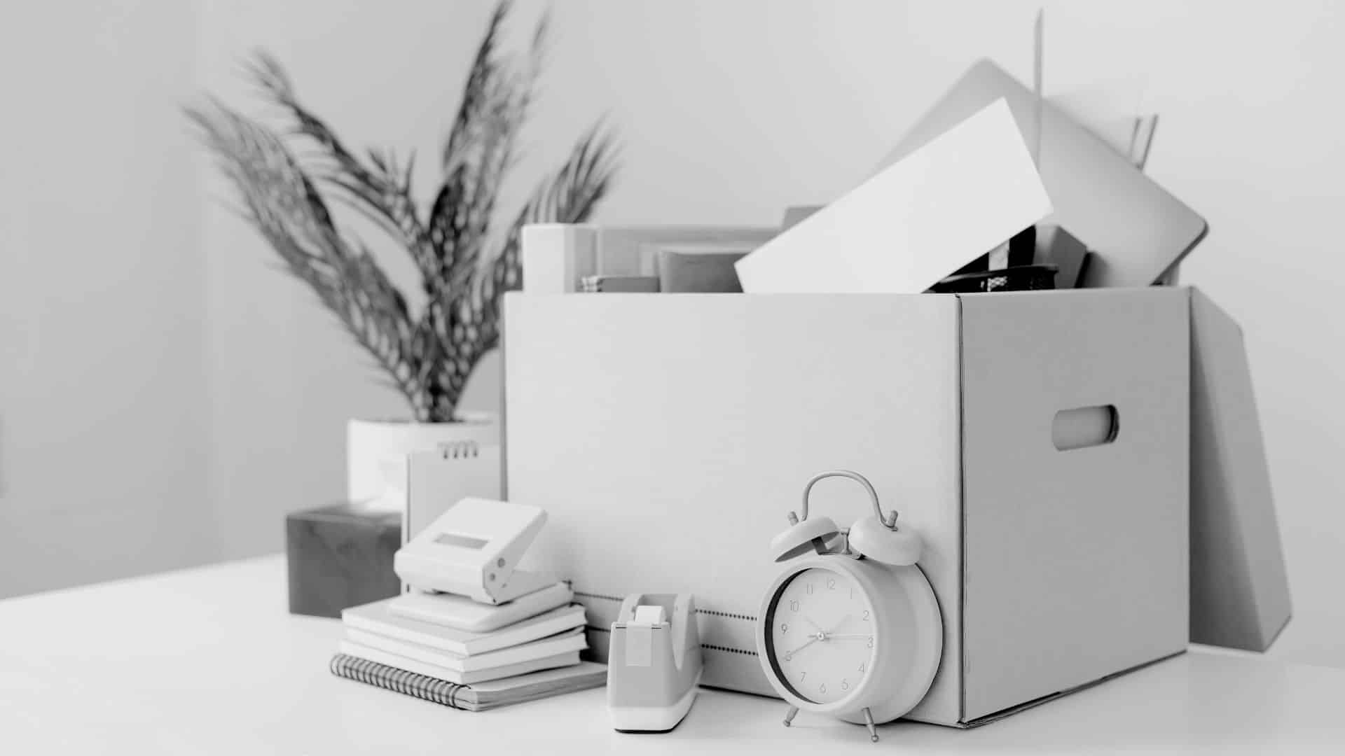 box of desk items for an employee about to be fired, the box is sitting on a desk