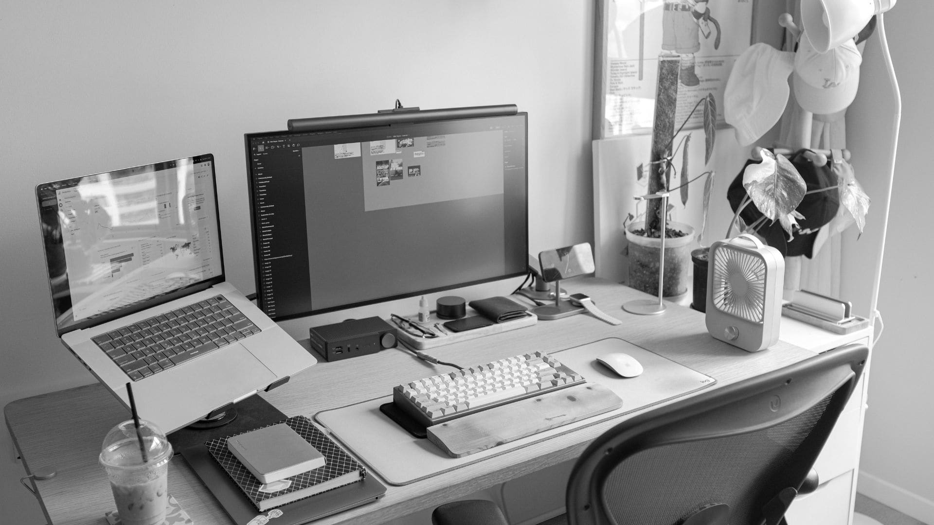 remote work desk with a desktop computer monitor, a laptop, and various work peripherals on it
