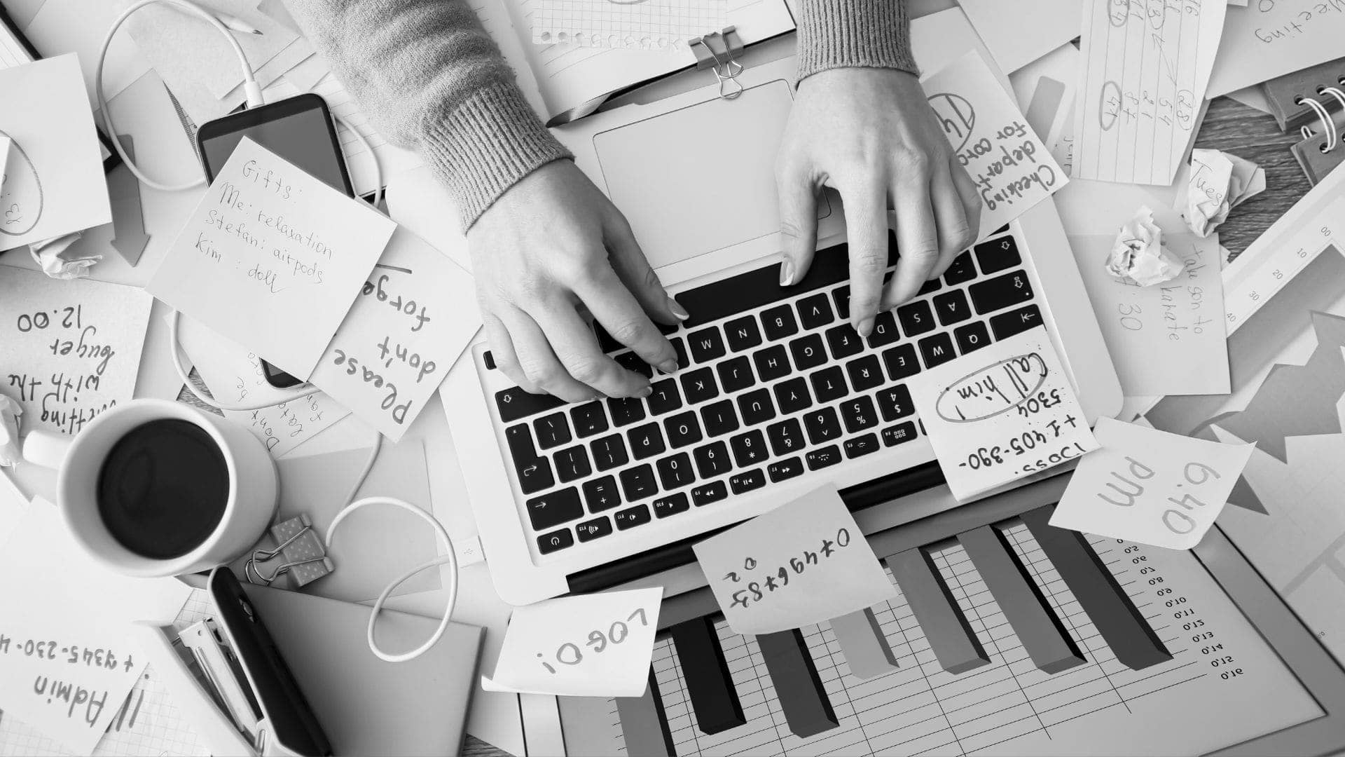 cluttered desk of a stressed out employee, evidenced by the post-it notes strewn across everything
